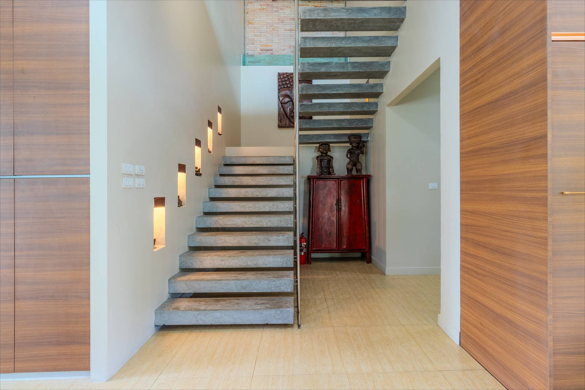 Modern floating concrete staircase with recessed wall lighting