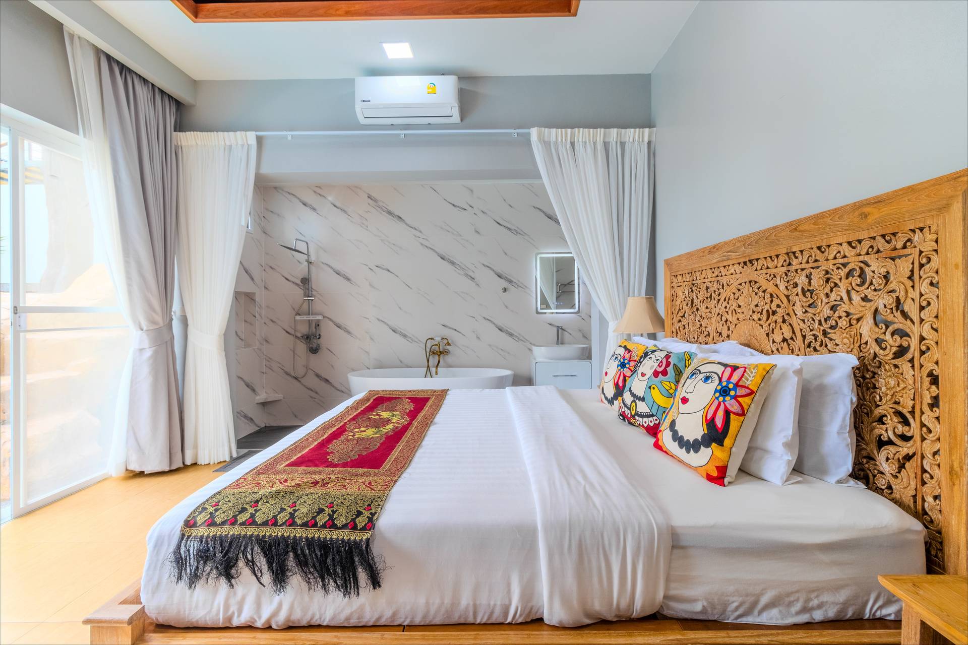 Tranquil garden-view bedroom with floor-to-ceiling windows framing the lush tropical landscape beyond