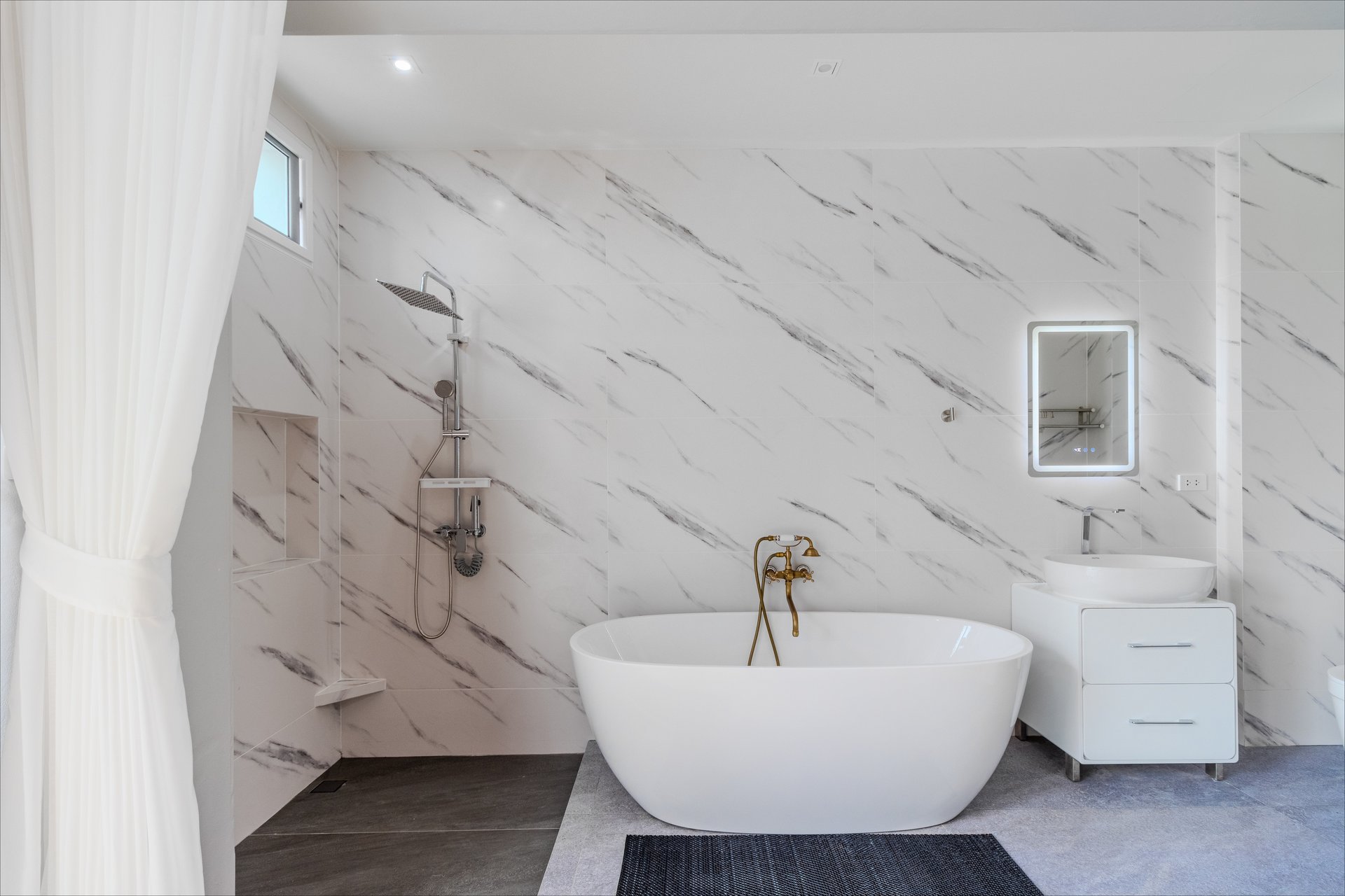 Luxurious en-suite with freestanding soaking tub and white marble walls