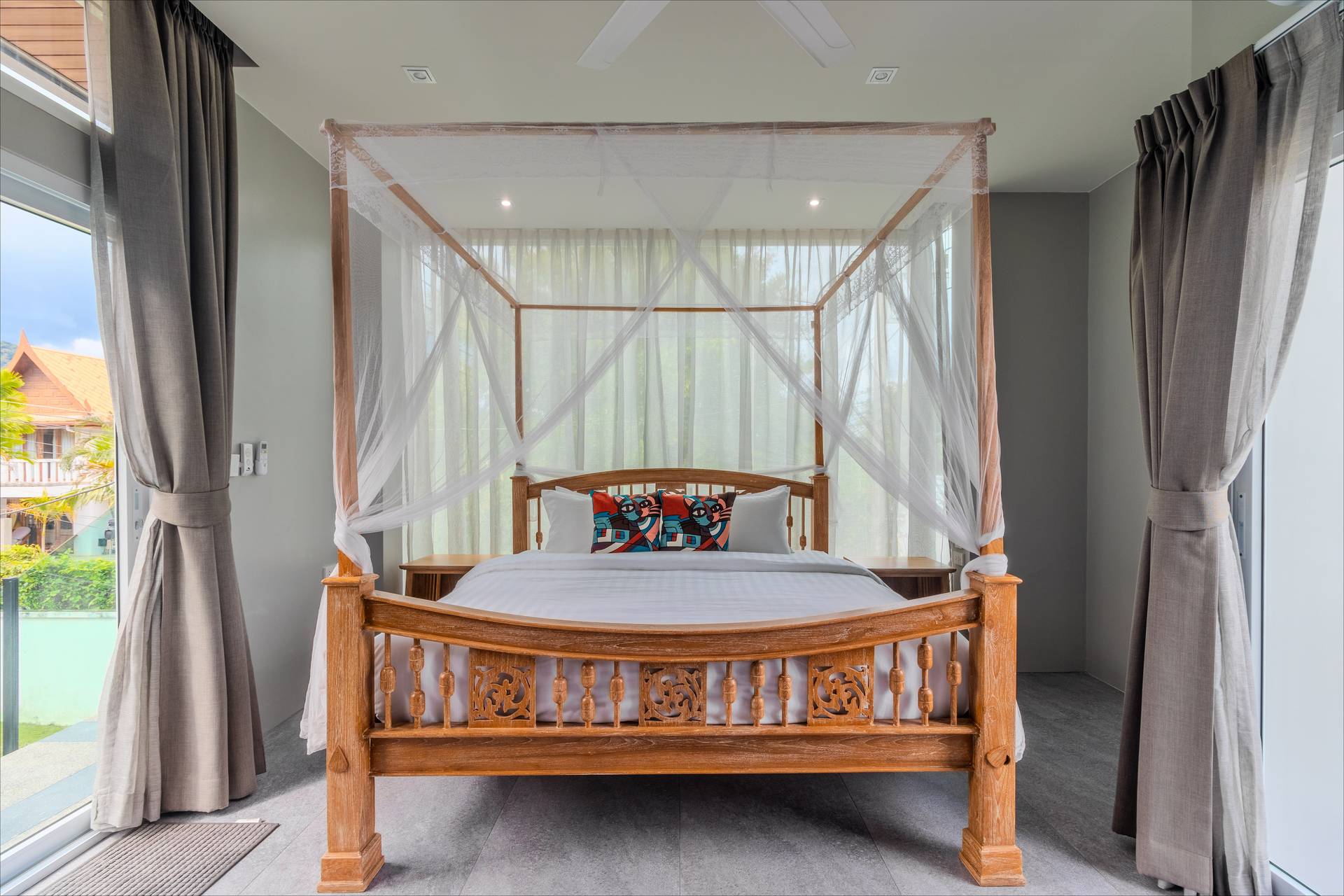 Elegantly appointed guest bedroom with quality linens, ambient lighting, and contemporary tropical decor