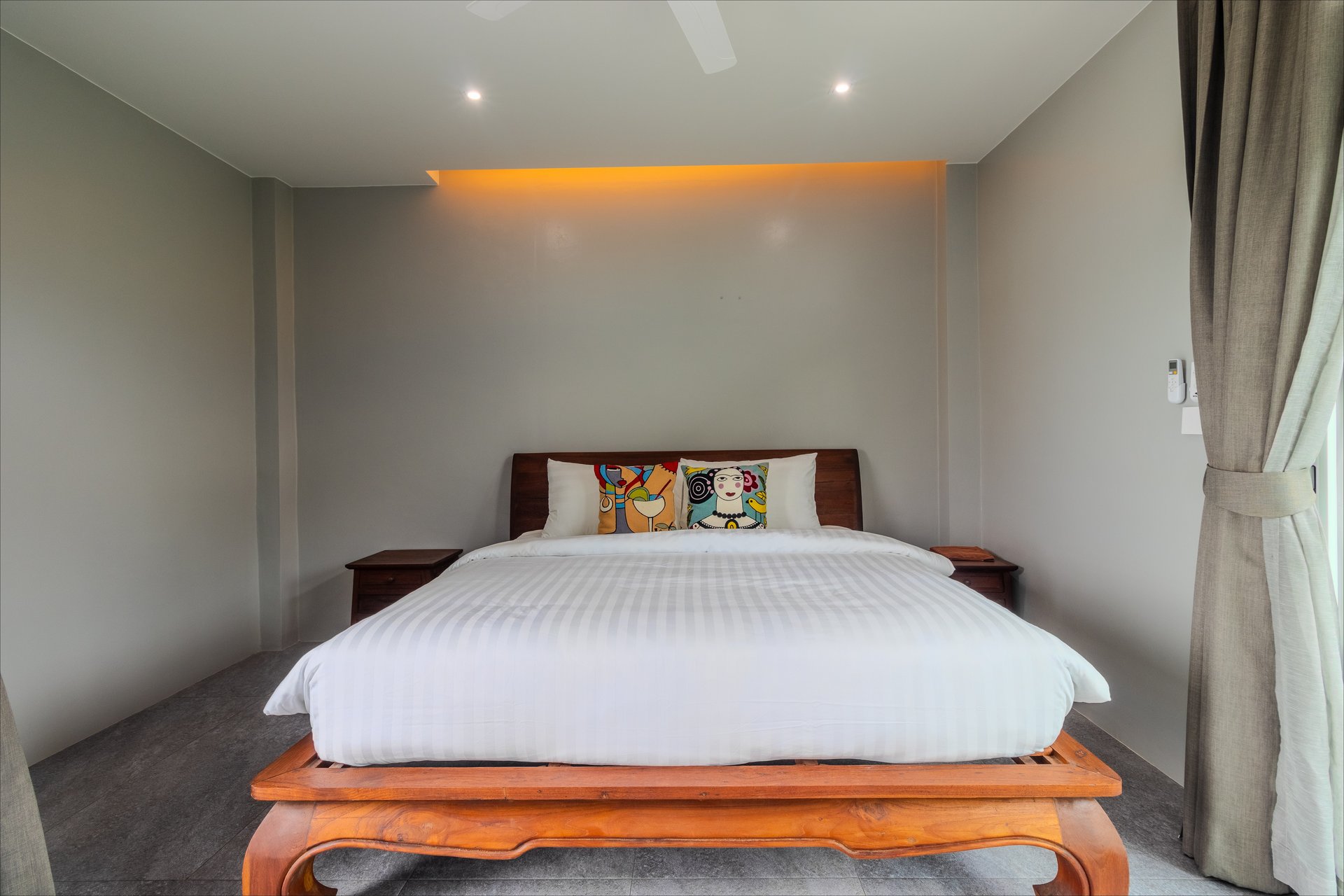 Minimalist king bedroom with warm LED backlighting and artisan cushions