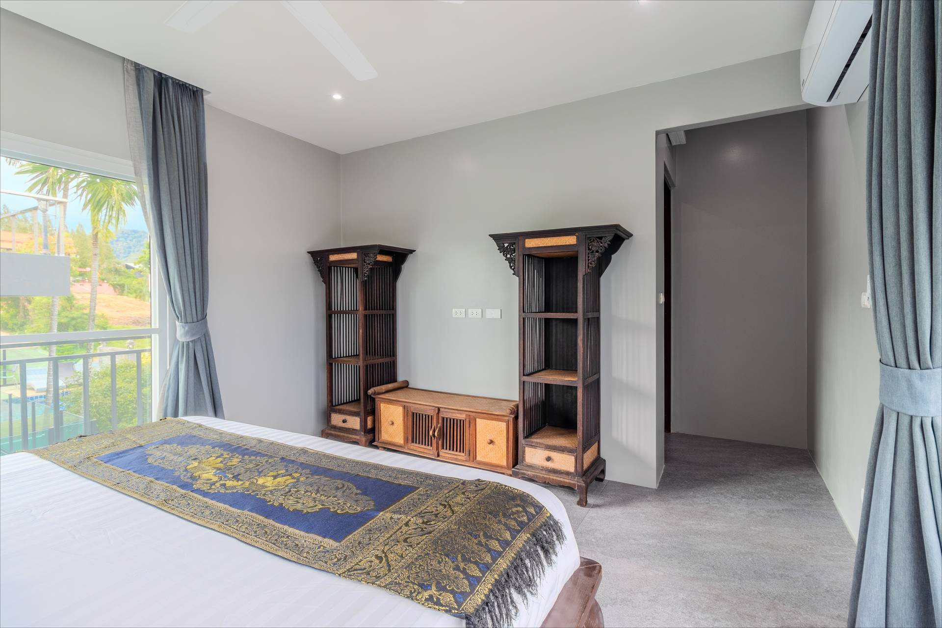Spacious bedroom with Thai silk bed runner and pool-area views