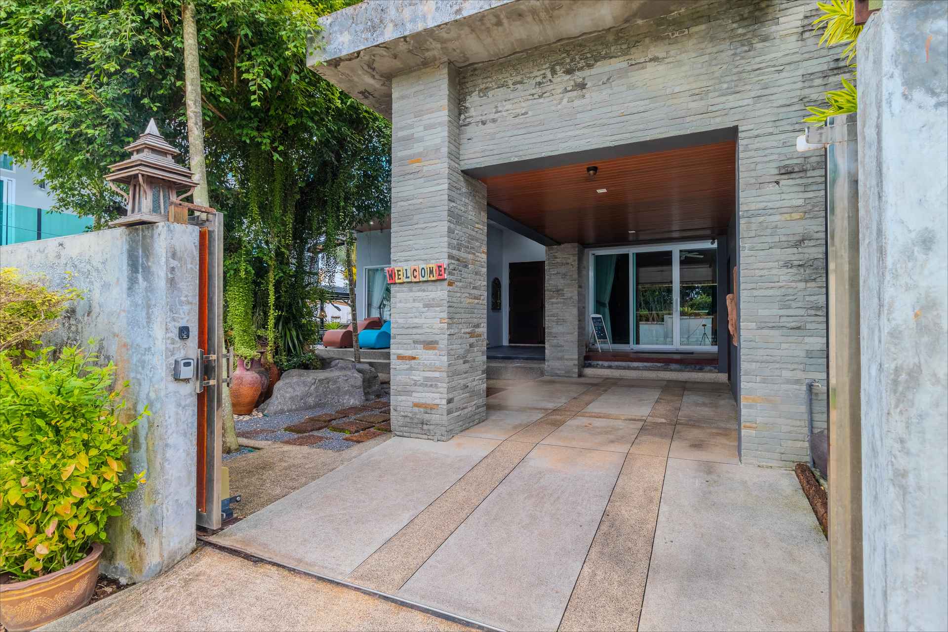 Contemporary stone-clad entrance portico with covered carport