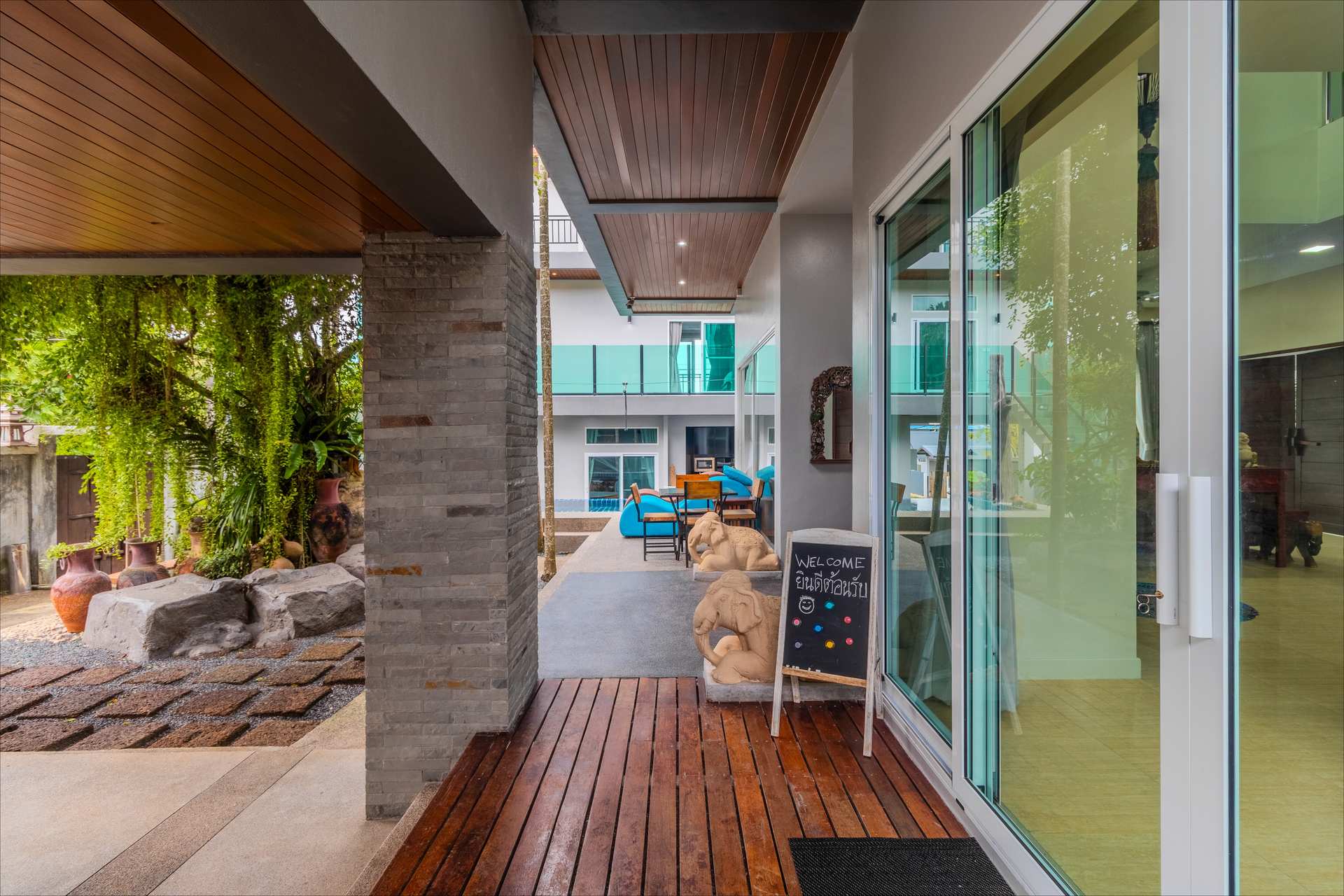 Covered wooden deck walkway with elephant statues and garden views