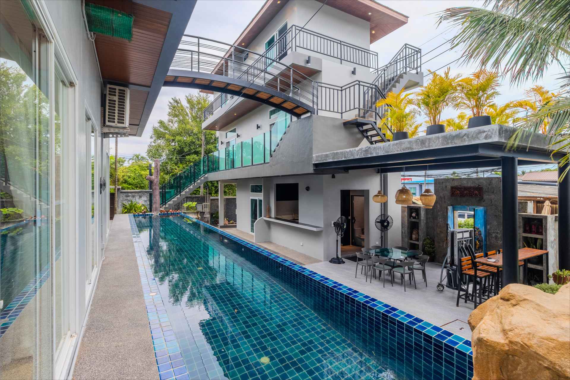 Relaxation pool with sun loungers and deck area surrounded by lush tropical vegetation at the estate
