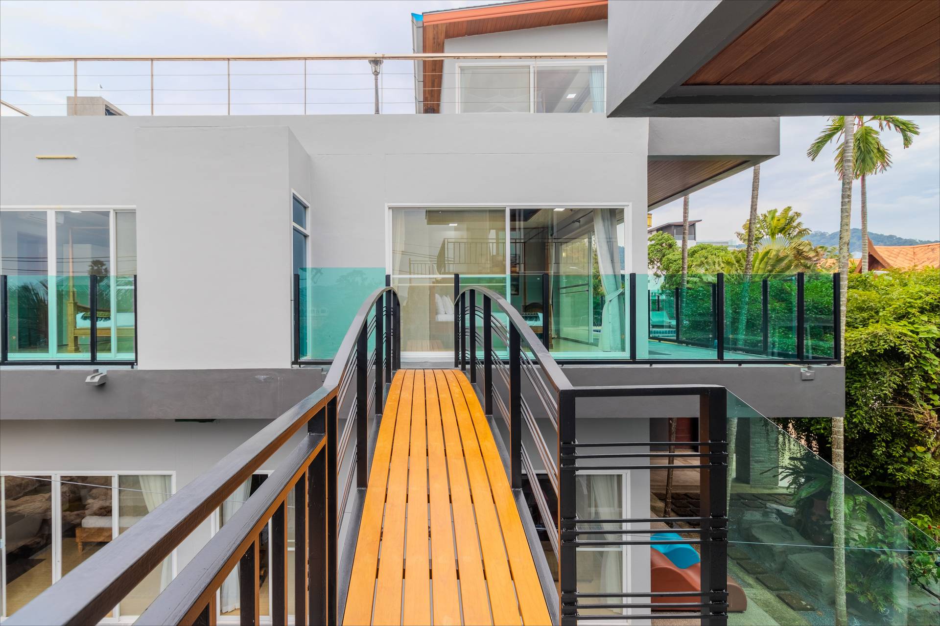 Elevated wooden sky bridge connecting villa buildings with panoramic views
